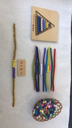 several different colored beads are on display next to a wooden bead holder and string