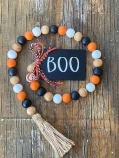 an orange, white and black beaded bracelet with the word boo on it