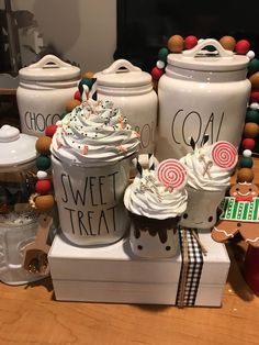 some white jars with cupcakes and candy on them