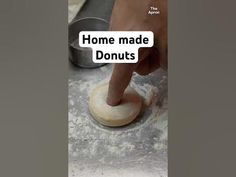 a person is kneading dough on top of a table with the words home made donuts