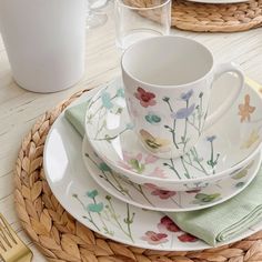 a table set with plates, cups and utensils on top of each other