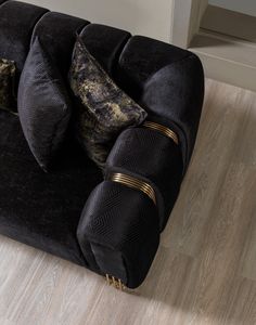 a black couch with gold trim and pillows