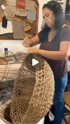 a woman standing in front of a basket on top of a table