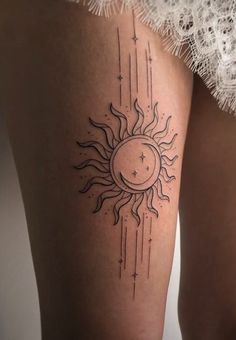 a woman's thigh with a sun and stars tattoo on it