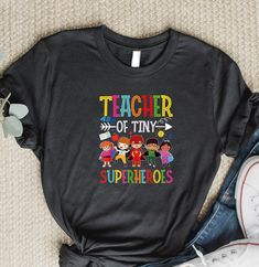 Teacher Of Tiny Superheroes Shirt, Back To School T-Shirt, Teacher Shirt, Tiny Teacher Shirt, Kindergarten Pre-K Teacher Of Tiny Superheroes High quality and super soft, comfortable shirt. Made with top of the line vinyl and pressed with a professional grade heat press. SIZING AND COLORS Make sure you check our size-chart before you place your order. If you are not sure about sizing please measure your favorite t-shirt and compare measurements to the chart for the best fit for you. For detailed sizing information and t-shirt color options, please see listing images. H O W TO O R D E R T - S H I R T 1-) Please, Check and Review all Photos. 2-) Select Your T-shirt Color. 3-) Select Your T-shirt Size. 4-) Click ADD TO CART and You can go back to add more product color and text color or You ca Superhero Cotton T-shirt With Letter Print, Superhero Cotton Tops With Letter Print, Pre K Teacher, Teacher Shirts, Text Color, Heat Press, The Line, Shirt Color, Custom Orders