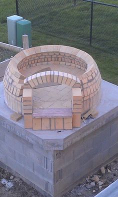 a brick oven sitting on top of a cement block