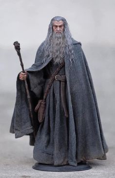 an action figure is shown with a long gray beard and grey robe, holding a staff