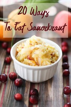 a white bowl filled with food on top of a wooden table next to cranberries