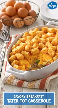 a casserole dish with tater tots in it on a table next to eggs