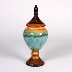 a ceramic vase with a wooden lid on a white background