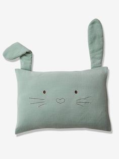 a green pillow with a bunny face on the front and ears in the back, it's made out of linen