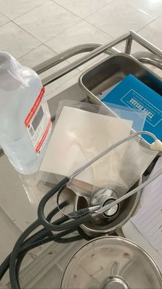 a bottle of water sitting on top of a table next to a stethoscope