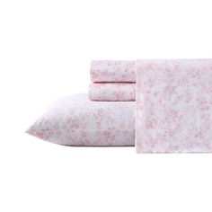 two sheets with pink flowers on them are next to one pillow and the other is white