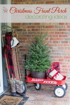 a small christmas tree sitting on top of a red wagon next to a brick wall