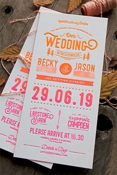 wedding stationery is laid out on a wooden table with autumn leaves and twine