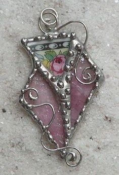 a pink and white glass pendant on a silver chain