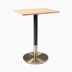 a square wooden table with a black base and a gold plated metal base on an isolated white background