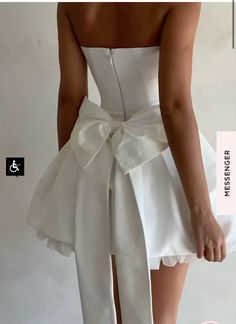 the woman is wearing a white dress with a big bow on it's waist