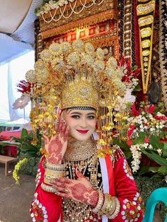 a woman dressed in red and gold holding her hands up