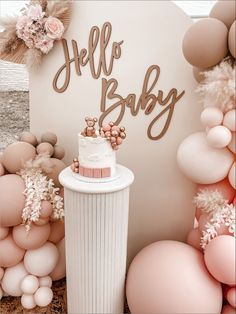 a cake sitting on top of a white table next to balloons and flowers in the air