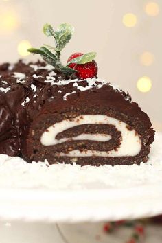 a piece of chocolate cake with white frosting and strawberries on top, sitting on a plate