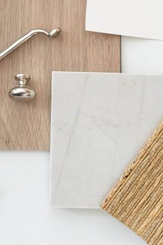 a white marble tile next to a wood and metal faucet on top of a table