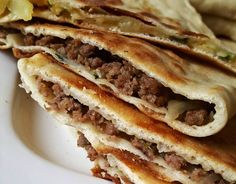 three quesadillas stacked on top of each other with meat in the middle