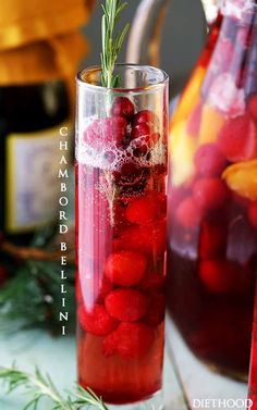 cranberry lemonade punch in a tall glass with rosemary garnish