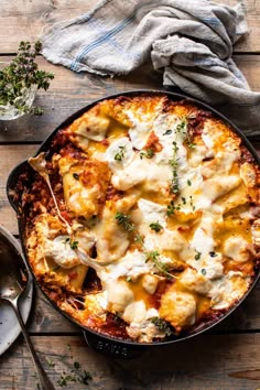 a casserole dish with chicken and cheese in it on top of a wooden table