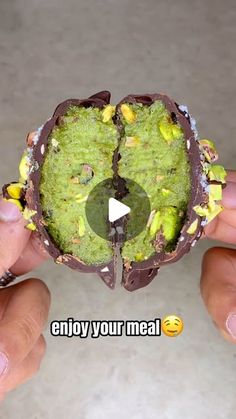 someone is holding up a piece of food that looks like an egg with chocolate and sprouts on it