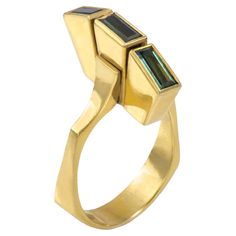 A green tourmaline and 18k gold ring, by Peter Cullman, c. 1990, South Africa. Stamped 18ct., Cullman. The ring is a 7.5. This ring is sizable. This ring is something of a shape shifter when seen from various angles but always recognizable as the work of Peter Cullman whose work has been exhibited internationally. German-born Cullman emigrated to South Africa in 1960s and has received an award in every category of the Intergold jewellery competition in Johannesburg. He was Chief Designer for renowned Montreal jewelers Lucas Jewellers - also collected by Mahnaz Collection - before setting up his own studio in Toronto, Canada. Modern Gold Tourmaline Rings, Modernist Green Rings For Anniversary, Green Modernist Rings For Anniversary, Modernist Green Ring For Formal Occasions, Gold Tourmaline Rings With Polished Finish, Formal Yellow Gold Emerald Ring, Paraiba Tourmaline Ring, Chrome Tourmaline, Shape Shifter