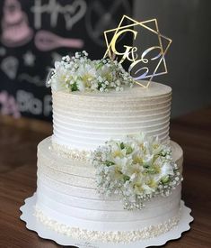 a white wedding cake with flowers on the top and initials on the side that says g & s