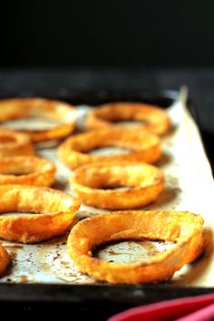 some onion rings are sitting on a baking sheet