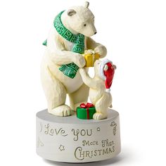 a white polar bear figurine holding a red fire hydrant with the words i love you more than christmas written on it