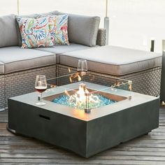 a fire pit sitting on top of a wooden floor next to a couch and table