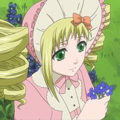 a girl with long blonde hair and green eyes wearing a pink dress holding flowers in her hand