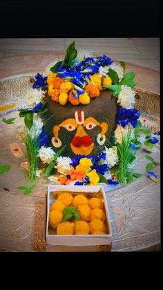 there is a decorated cake with flowers in the middle and a box on the floor next to it