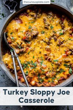 turkey sloppy joe casserole in a skillet with two serving utensils