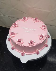 a pink birthday cake with flowers on the top and words on the side that says, robert family add