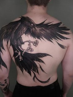 a man with a black bird tattoo on his back