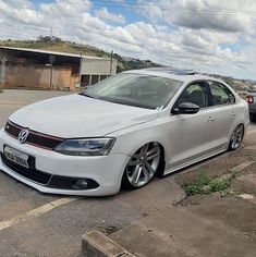 a white car is parked on the side of the road