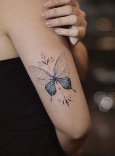 a woman with a butterfly tattoo on her arm