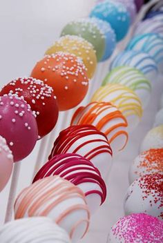 several colorful candy lollipops lined up in a row with sprinkles on them