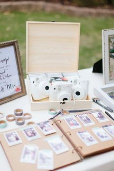 a table topped with pictures and photos next to a wooden box filled with wedding rings