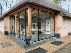 a house with glass walls and a thatched roof