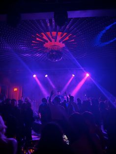 a group of people standing on top of a stage in front of purple and blue lights