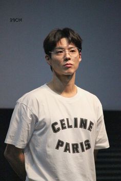 a man with glasses standing in front of a projector screen wearing a t - shirt that says celline paris