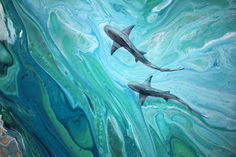 two dolphins swimming in the ocean with blue and green paint on it's walls