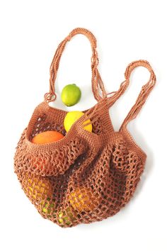 an orange and green fruit in a brown net bag