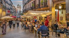 many people are sitting at tables in the street